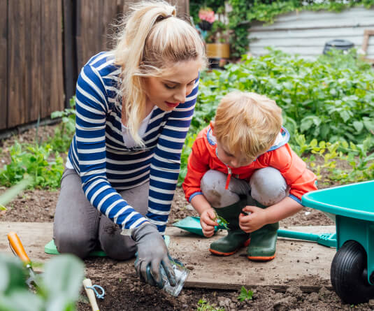 Mom and toddler planting in a garden
